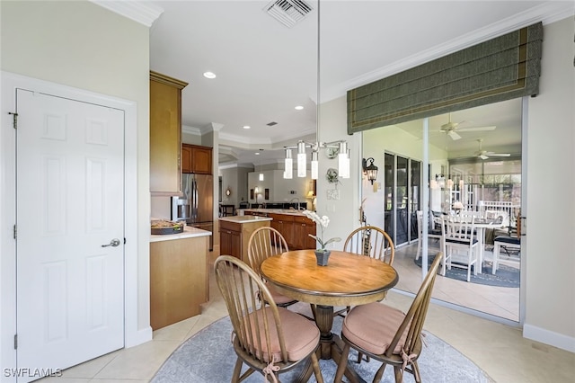 tiled dining space featuring sink, crown molding, and ceiling fan