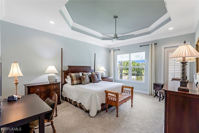 carpeted bedroom with crown molding, ceiling fan, and a raised ceiling