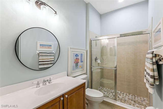 bathroom featuring vanity, an enclosed shower, and toilet