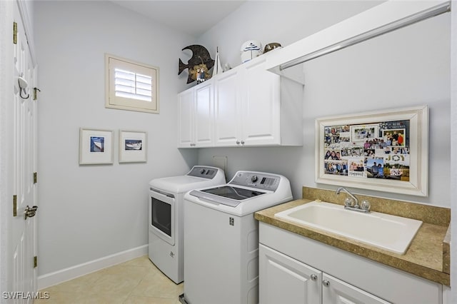 laundry area with sink, light tile patterned floors, cabinets, and independent washer and dryer