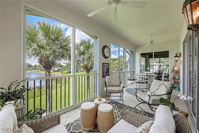 sunroom / solarium featuring ceiling fan and a water view