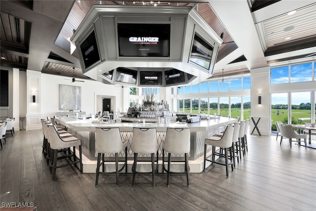 bar featuring a high ceiling, hardwood / wood-style floors, and ceiling fan