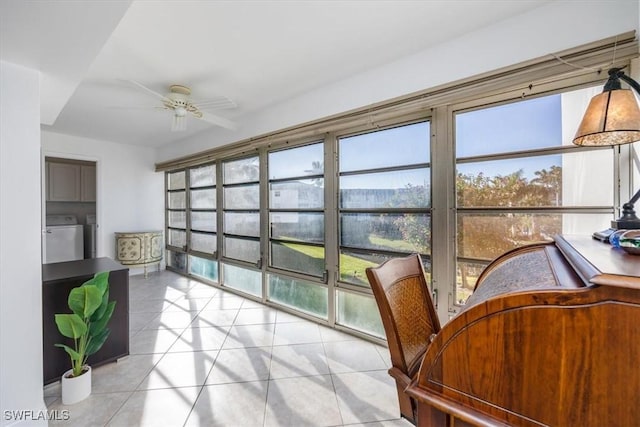 sunroom with ceiling fan and washing machine and dryer