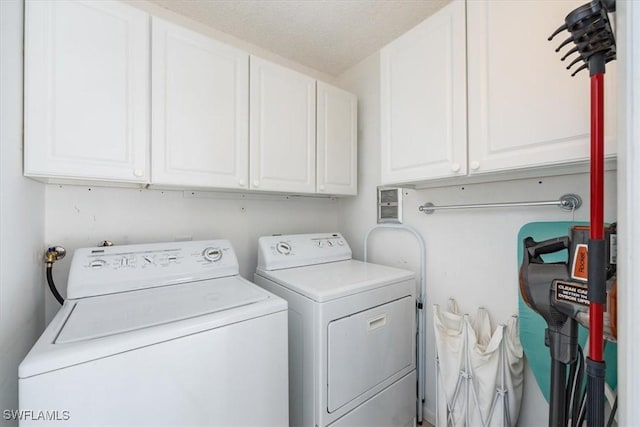 washroom featuring washing machine and dryer and cabinets