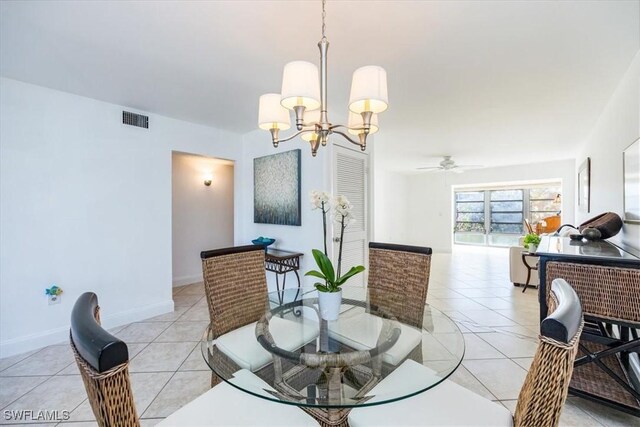 dining space featuring light tile patterned flooring and ceiling fan with notable chandelier