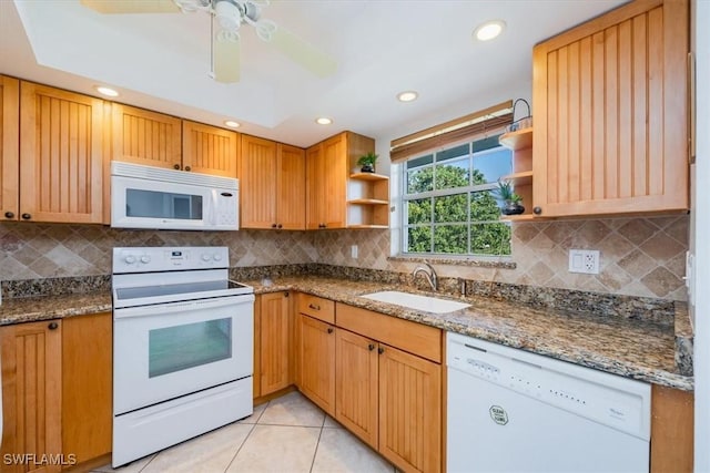 kitchen with white appliances, stone counters, light tile patterned flooring, backsplash, and sink