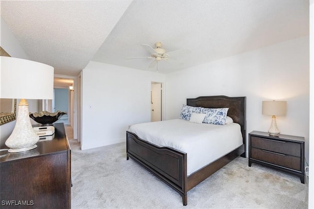 bedroom featuring ceiling fan, light carpet, and a textured ceiling