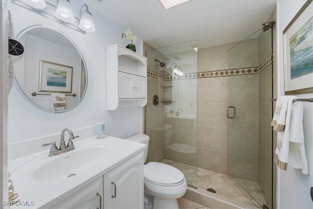 bathroom with toilet, vanity, and walk in shower