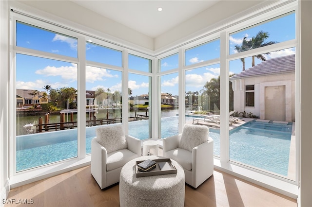 sunroom featuring a water view