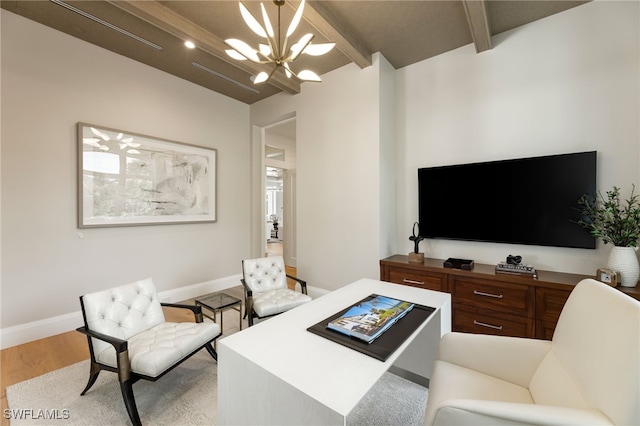 living room with a notable chandelier, beam ceiling, and light hardwood / wood-style floors