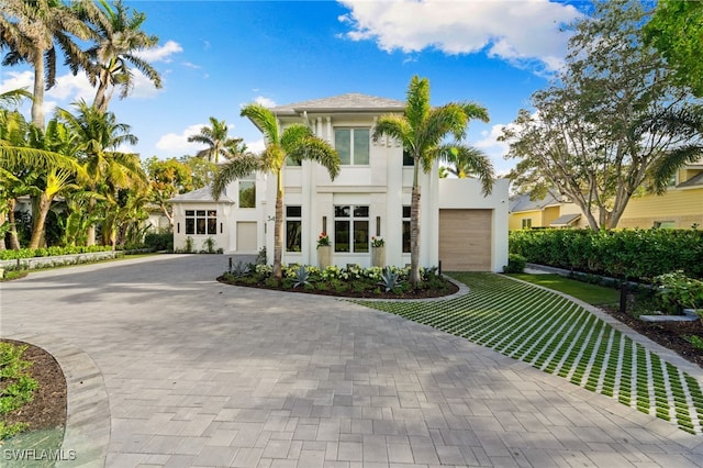 mediterranean / spanish-style home with a garage and a front lawn