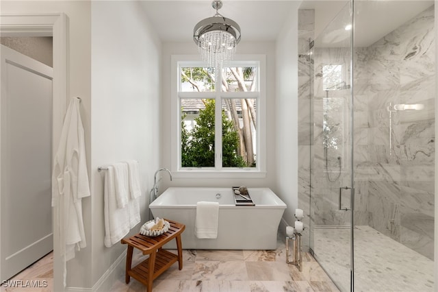 bathroom featuring a wealth of natural light, a chandelier, and separate shower and tub