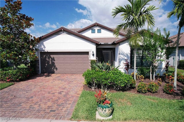 view of front facade with stucco siding, decorative driveway, and a garage