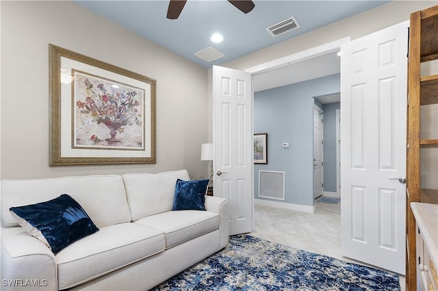 living area featuring ceiling fan, light tile patterned floors, and baseboards