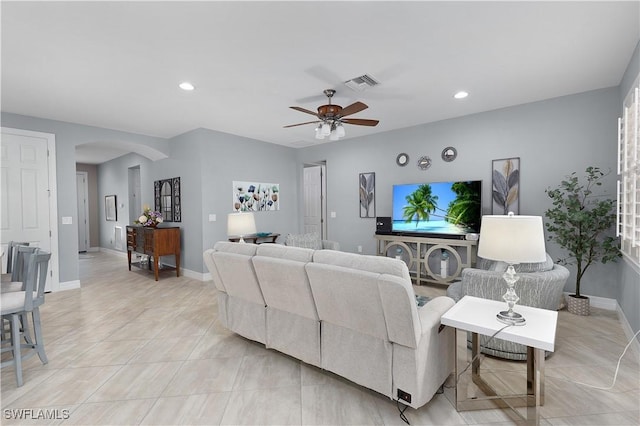 living room with arched walkways, ceiling fan, light tile patterned flooring, recessed lighting, and baseboards