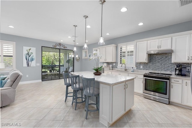 kitchen with stainless steel electric range oven, under cabinet range hood, open floor plan, light tile patterned flooring, and recessed lighting
