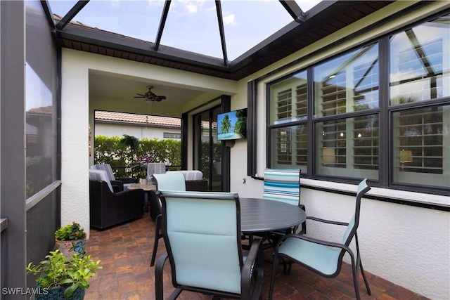 sunroom / solarium featuring a ceiling fan, outdoor dining space, and healthy amount of natural light