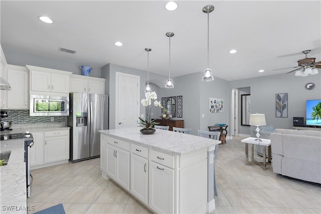kitchen with stainless steel appliances, open floor plan, light tile patterned flooring, a center island, and recessed lighting
