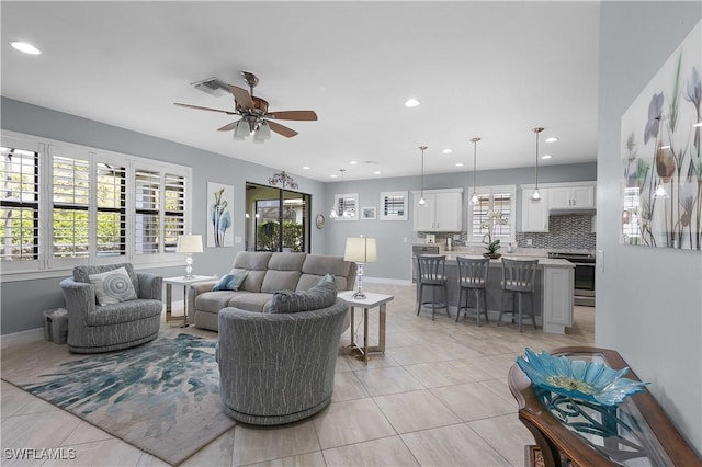 living room featuring light tile patterned floors, ceiling fan, baseboards, and recessed lighting