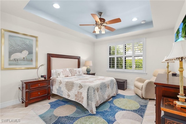 bedroom featuring a raised ceiling, baseboards, recessed lighting, light tile patterned floors, and ceiling fan