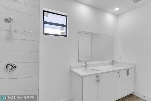 bathroom with vanity and tiled shower