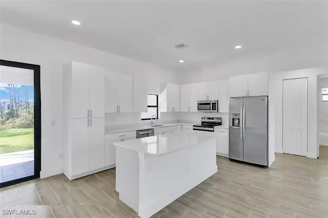 kitchen with white cabinetry, sink, a center island, and appliances with stainless steel finishes