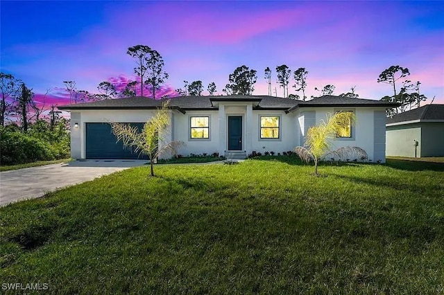 view of front of home featuring a garage and a lawn