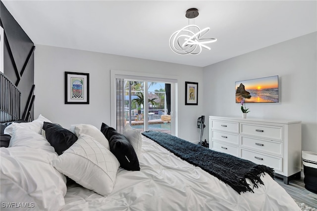 bedroom with a chandelier, light hardwood / wood-style floors, and access to outside