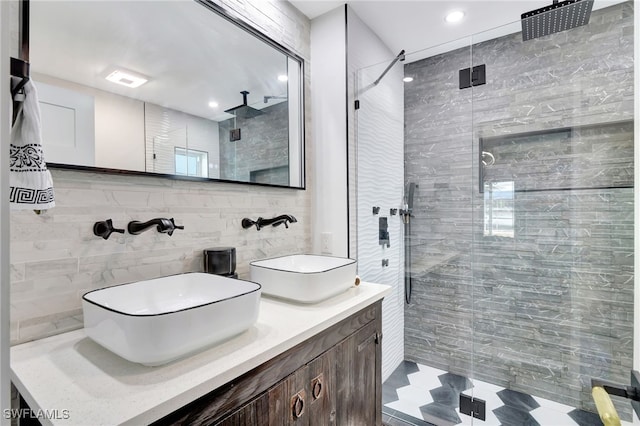 bathroom with walk in shower, vanity, and tile walls