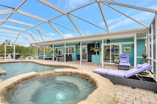 view of pool featuring outdoor lounge area, a patio, ceiling fan, and an in ground hot tub