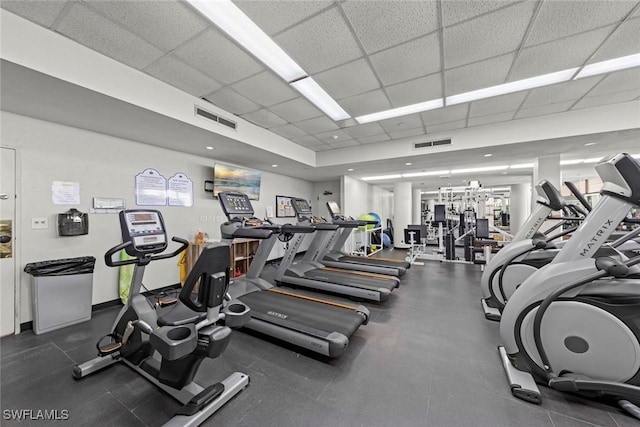 exercise room featuring visible vents, baseboards, and a drop ceiling