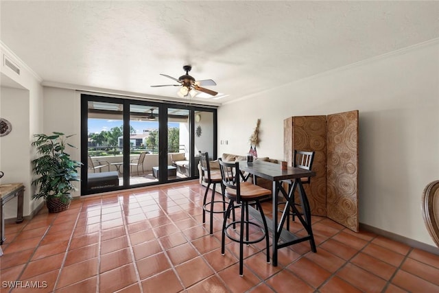 tiled dining area with crown molding, a textured ceiling, and ceiling fan