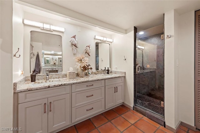 full bath with double vanity, a shower stall, tile patterned floors, and a sink