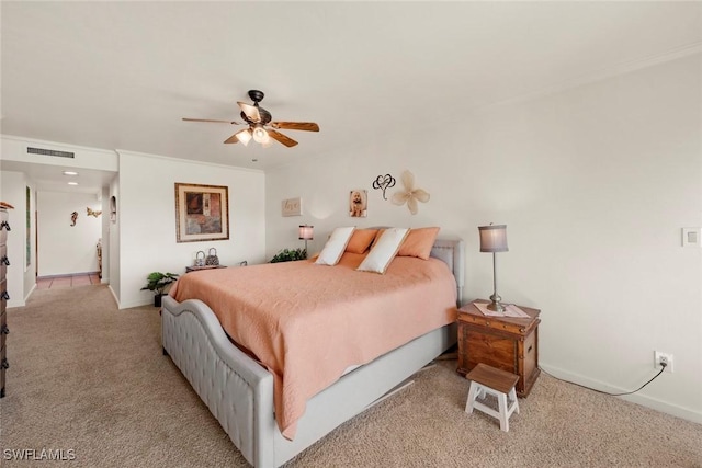 bedroom with visible vents, ornamental molding, a ceiling fan, baseboards, and light colored carpet