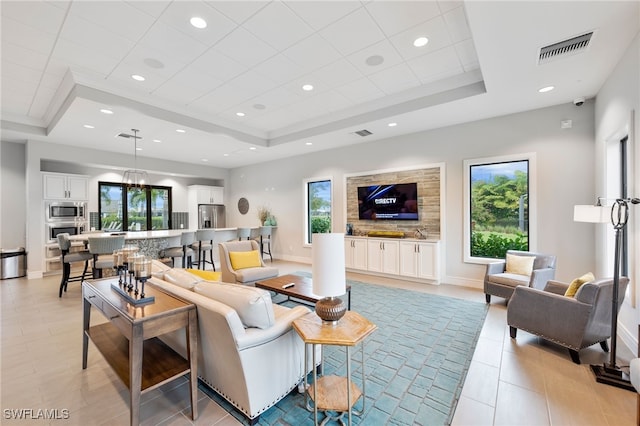 living room with a raised ceiling and a wealth of natural light