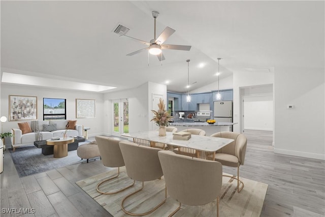 dining area with ceiling fan, lofted ceiling, and light wood-type flooring