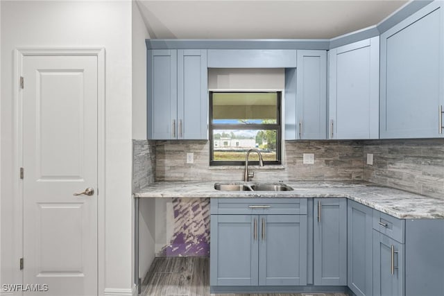 kitchen featuring tasteful backsplash, sink, and light stone counters