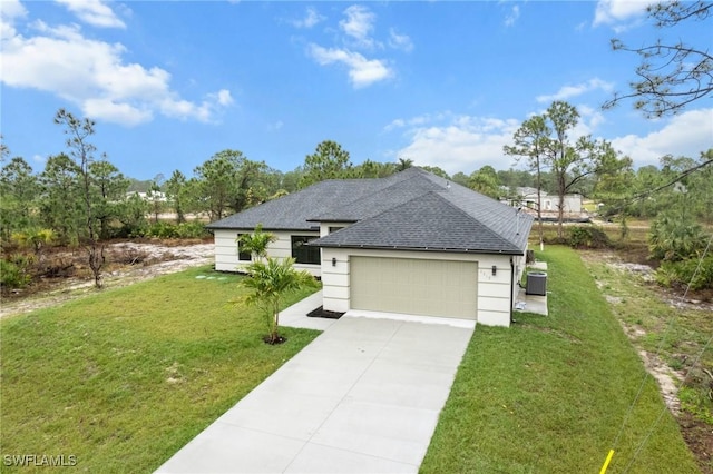 view of front of home with a garage, central AC, and a front lawn