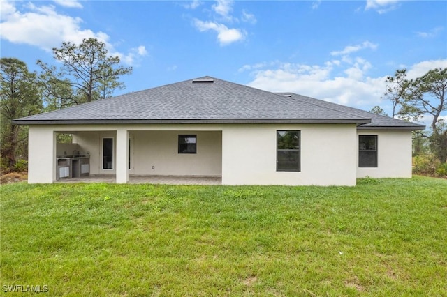 rear view of property with a patio and a lawn