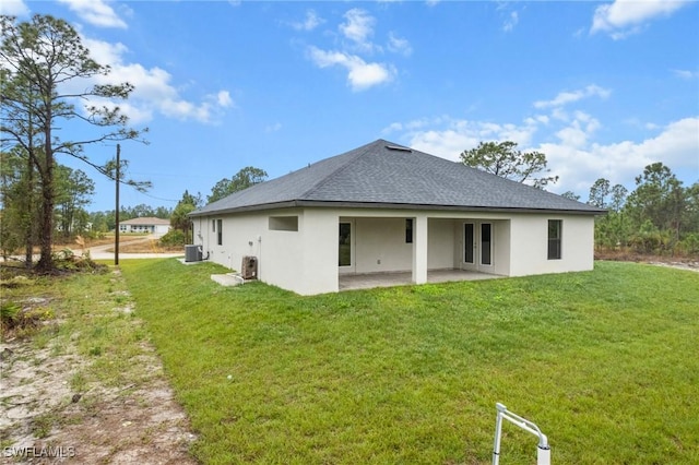 rear view of property with central AC, a yard, and a patio area