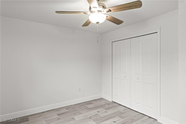 unfurnished bedroom featuring light hardwood / wood-style flooring, a closet, and ceiling fan