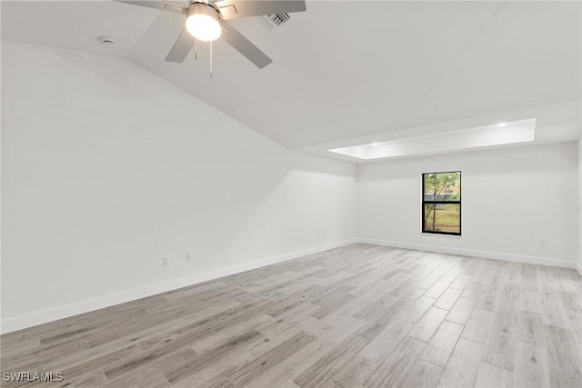 empty room with ceiling fan, lofted ceiling, and light hardwood / wood-style floors