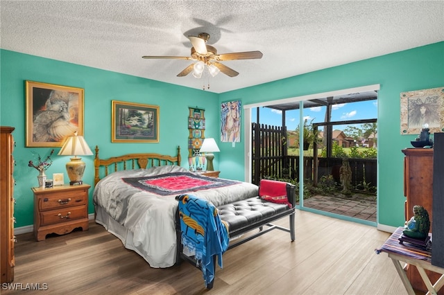 bedroom with hardwood / wood-style flooring, access to outside, a textured ceiling, and ceiling fan