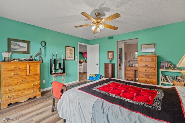 bedroom with hardwood / wood-style flooring, ceiling fan, and a textured ceiling