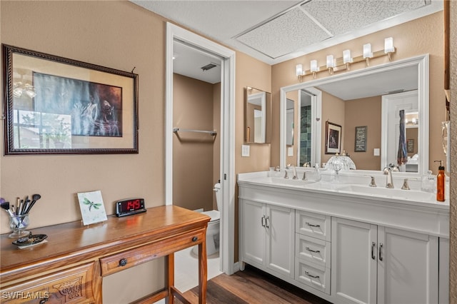 bathroom with vanity, toilet, and hardwood / wood-style floors