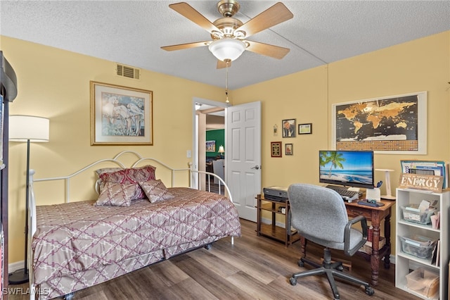 bedroom with ceiling fan, hardwood / wood-style flooring, and a textured ceiling