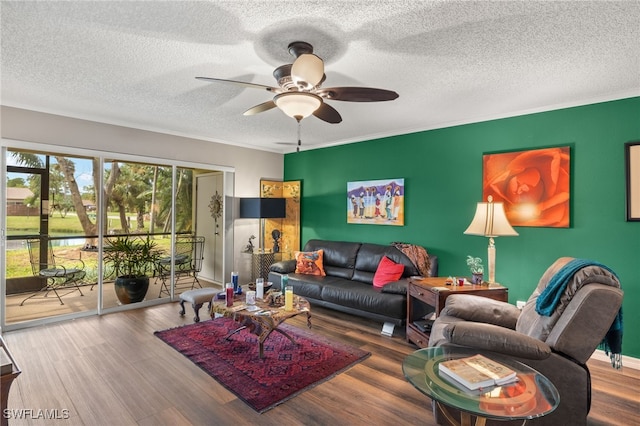 living room featuring wood-type flooring, a textured ceiling, ceiling fan, and crown molding