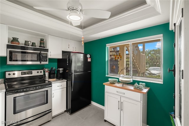 kitchen featuring a raised ceiling, white cabinetry, appliances with stainless steel finishes, and ornamental molding