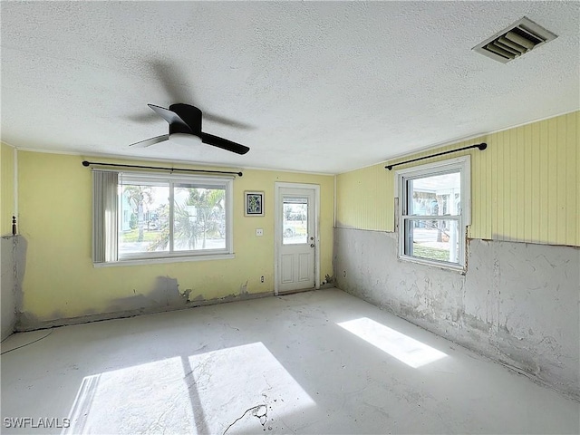 empty room featuring ceiling fan and a textured ceiling