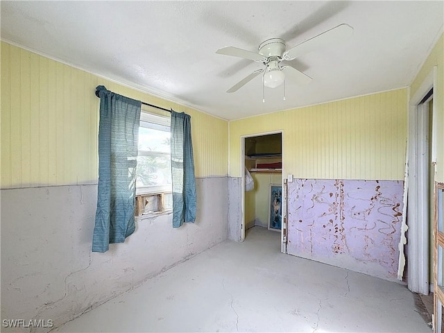 unfurnished room with a ceiling fan and concrete flooring